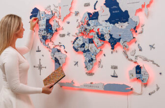 3D LED wooden world map in aqua tones mounted on a living room wall