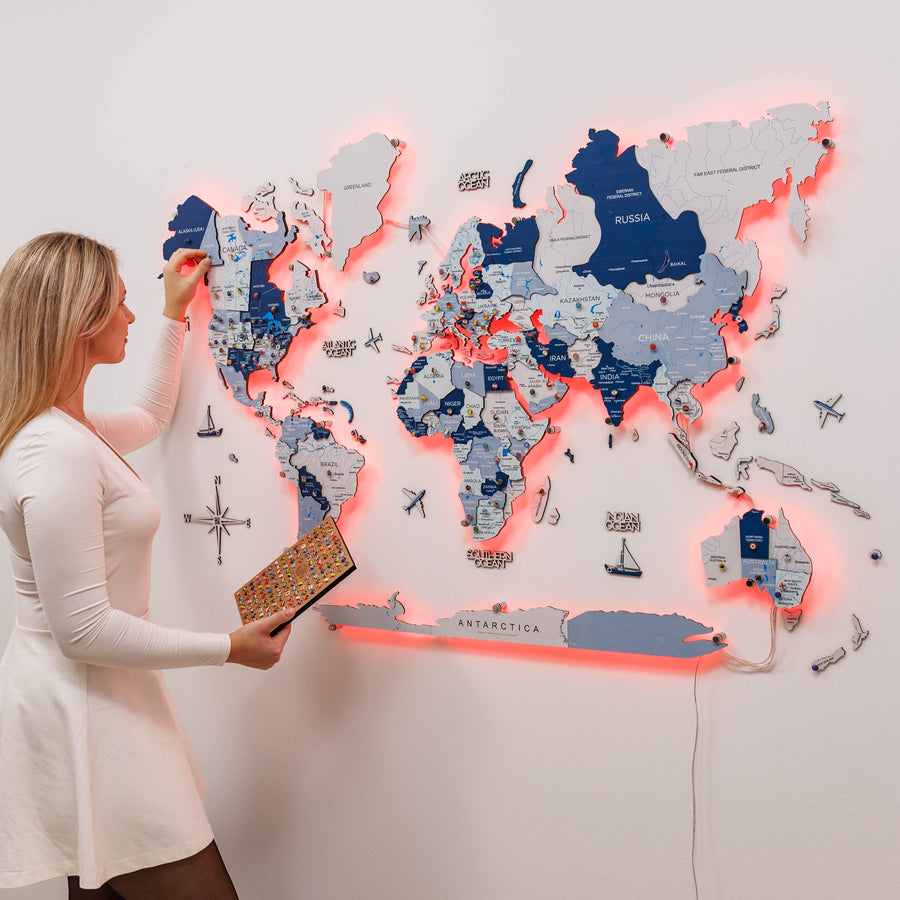3D LED wooden world map in aqua tones on a living room wall