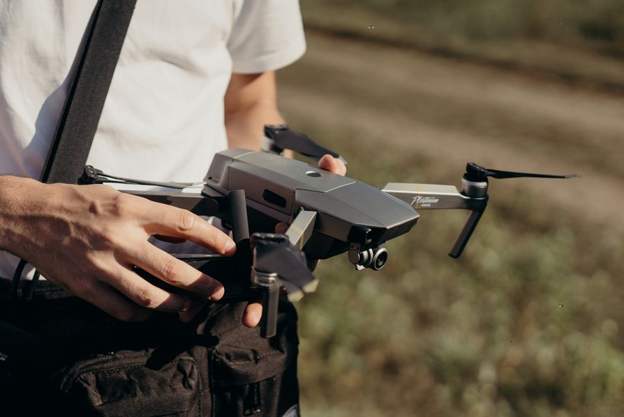 Close-up of hands holding a camera drone outdoors